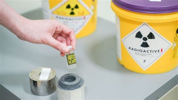 Should radioactive sources be touched by hand?